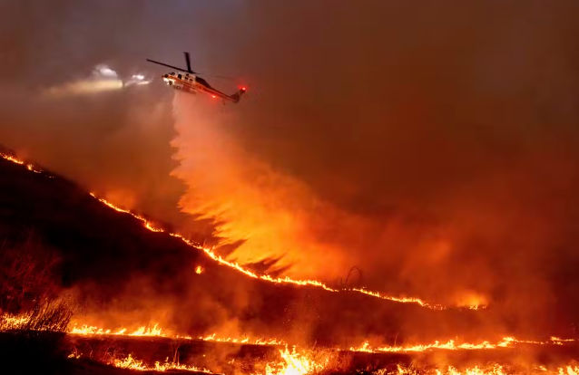 Helicóptero joga água sob as chamas do incêndio Kenneth em Los Angeles Foto Ethan SwopeAP Photo